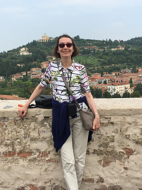 Bild von Christiane Binder vor einer Mauer lehnend in Verona