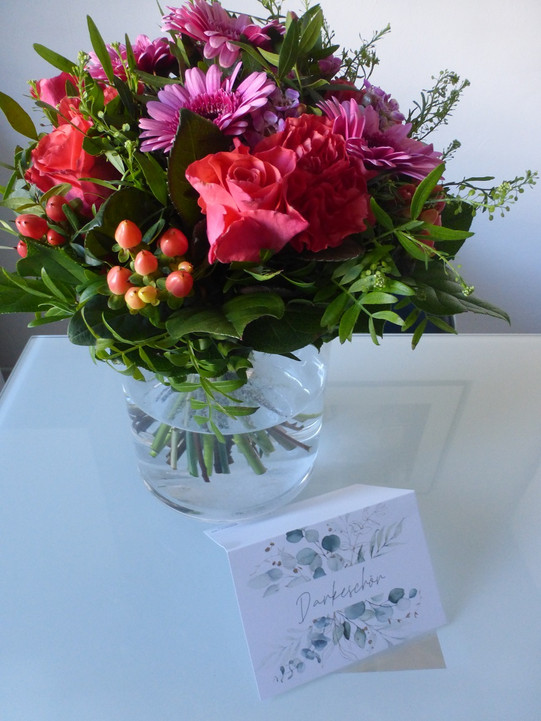 Blumenstrauß mit Blumen und einer Karte mit der Aufschrift: "Danke"