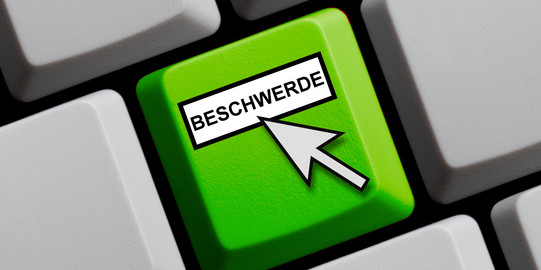 Beschwerde_Taste Eine grüne Taste mit dem Wort Beschwerde und einem hinweisenden Mauspfeil.