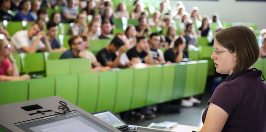 Studierende im Hörsaal Dozierende sitzt vor Studierenden im Hörsaal im Seminargebäude.