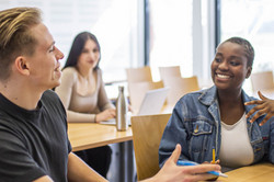 Studierende sitzen im Seminarraum und reden miteinander.