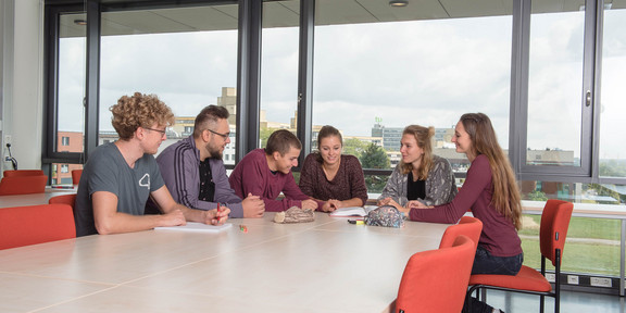 Lerngruppe Studierende sitzen mit Lernunterlagen am Tisch.