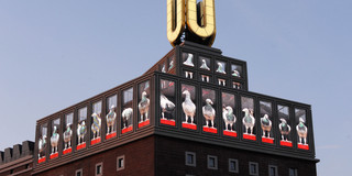 Das Dortmunder U mit Bildschirmen und blauem Himmel im Hintergrund.